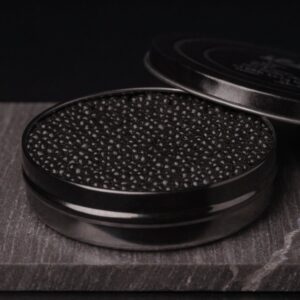 Open black caviar tin filled with deep jet-black Baeri pearls on dark stone
