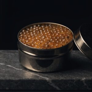 Open black caviar tin filled with amber-golden Oscietra pearls on dark stone